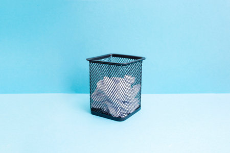 Wire mesh garbage basket with square profile on two toned blueの写真素材