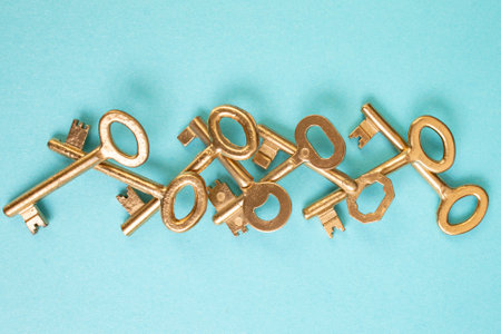 Vintage golden painted keys overlapping arranged on blue paper