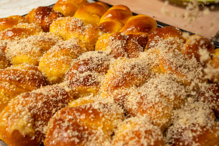Sprinkling grated nuts on sfintisori .Romanian cuisine. Homemade Mucenici, traditional desserts made...