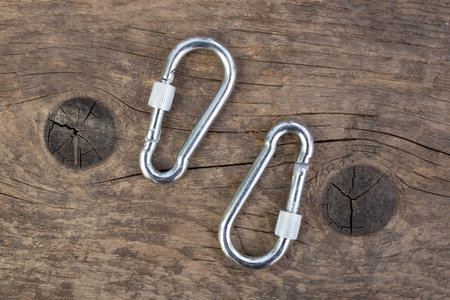 Two silver steel carabines on weathered wood background,の写真素材