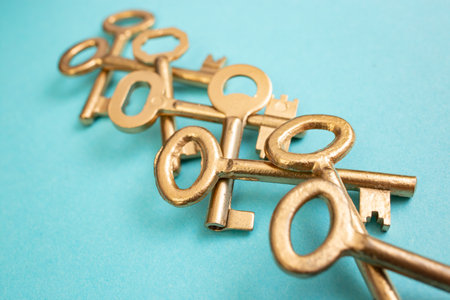 Vintage golden painted keys overlapping arranged on blue paperの写真素材