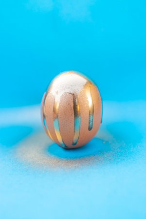 Golden spray paint trails on a sphere on blue
