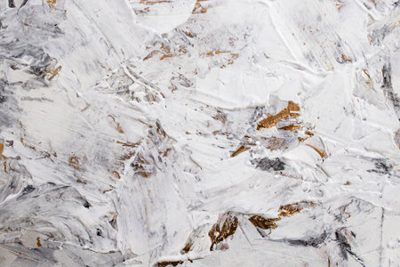 Putty white paste mixed with black ink, abstract close up detail of spatula strokes on golden paint stucco renovation,の写真素材