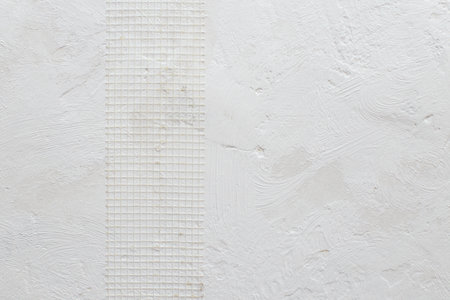 Plastic covering mesh band for even plastering on a white grungy wall, abstract textured  backdrop