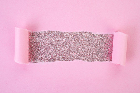 Ripped pink paper copy space revealing pink glitter, bohemian cosmetic backdrop, soft focusの写真素材