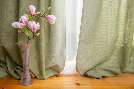 Empty backdrop on wooden floors with green fabric drapes and magnolia flowers, bohemian   backdropの写真素材