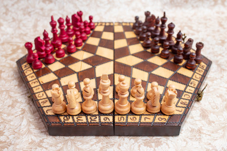 Three player chess board with black, white and red color pieces, on hexagonal  wooden boardの写真素材