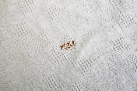 Ripped hole in a white textured white fabric table cloth,  backdropの写真素材