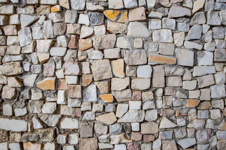 Square shaped granite cubes arranged randomly as a wall decoration, abstract patterned close up
