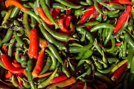 Green and  red chili peppers , scattered in a neat pile flat lay sunlit