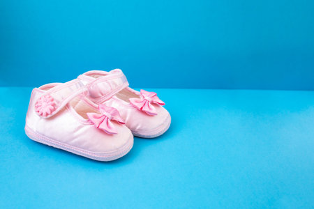 Pair of new born pink shoes flat lay on blue background, close upの写真素材