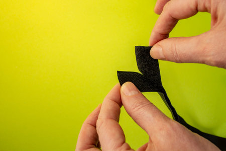 Hook and loop tape opened by woman fingers on green background