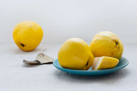 ripe quince on the kitchen table in a plateの写真素材