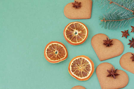 ginger cookies and fir branches on green background