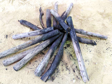 Stack firewood after blackout on the sandの写真素材