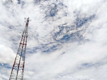 Telecommunication tower on blue sky clouds backgroundの写真素材
