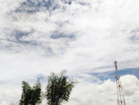 Telecommunication tower on blue sky clouds backgroundの写真素材
