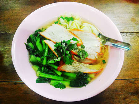 Chinese egg noodle with slice red barbecue on wooden background in vintage colour modeの写真素材