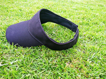 Golf hat on the green grass background