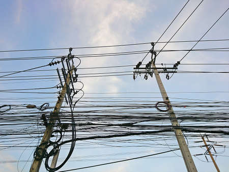 The electric poles supporting wires for various public utilities such as drop wire cable or fiber optic cableの写真素材