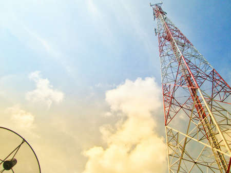 Telecommunication tower and satellite dish with sky background