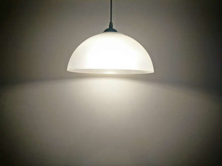 Black decorative lamp hanging from the ceiling on gray backgroundの写真素材