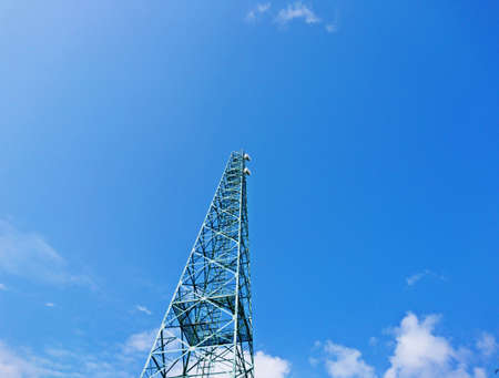 Green colour of telecommunication tower antenna on blue sky backgroundの写真素材