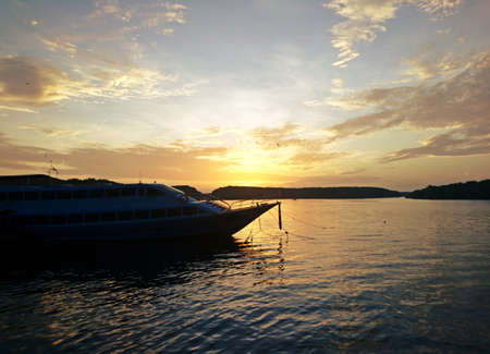 The view of the boat docked at the pier while the sun is risingの写真素材