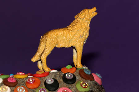 the wolf summons on a colorful stone on a purple backgroundの写真素材