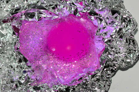 the inside of the egg in pink is covered with glitter on foil on a white background
