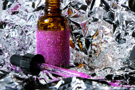 concept small bottle with glitter and glitter pipette on a gray metallic backgroundの写真素材