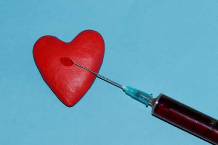 vaccine with red liquid in a red heart on a blue background vaccine injects loveの写真素材