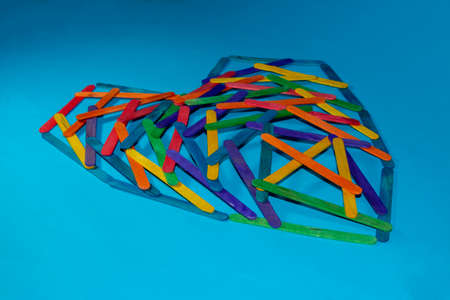 heart of wooden sticks on pastel blue background 3d composition creative arrangement