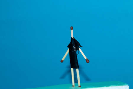 fashion model made of wooden matches creative concept of a fashion show made of flammable drceta in a black dress on a blue backgroundの写真素材