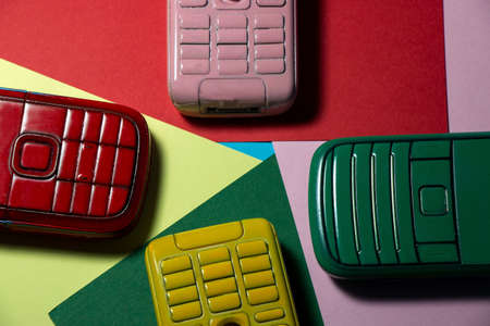 mobile phones in various colors with multicolored wallpaper