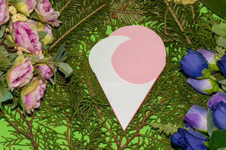 paper ice cream with pink and white ball on a natural background of evergreen leaves and colorful...