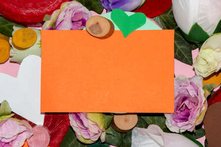 creative background full of flowers of small stumps of various sizes and colors and hearts, in the middle orange card as copy space, creative art natural spirng background, flat designの写真素材
