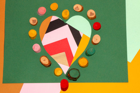 lots of colorful papers and heart shape, around the heart small colored stumps, creative art love...