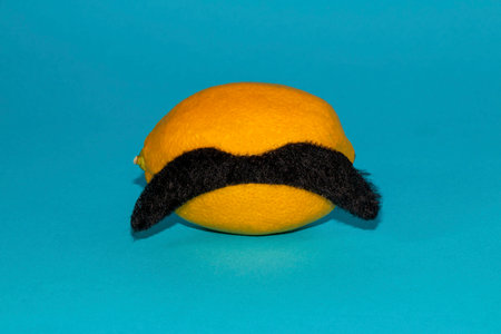lemon isolated on a blue background with a mustache, creative concept
