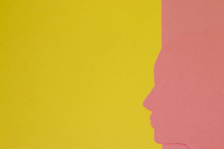 yellow papi as a copy space and pink paper from which a pink paper head emerges, a creative concept a silhouette that seems to emerge from pink, flat design, ideaの写真素材