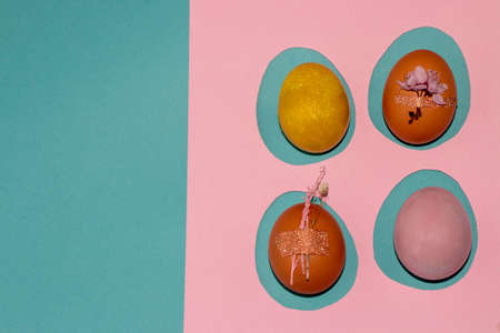 four colorful eggs on a pink template and a naughty background, creative art easter design, copy...