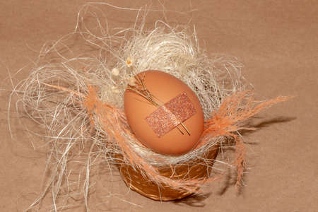 egg with glued small flower in a small wooden decorative basket, creative vintage easter concept, happy easterの写真素材