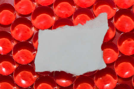 abstract red background with red beads and white torn paper as copy space, creative futuristic look...