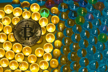 abstract futuristic vibrant background with 3d balls in various colors in the yellow part of bitcoin coins, new age cryptoworldの写真素材