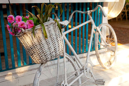 White bicycle with flowers in a wooden basketの写真素材