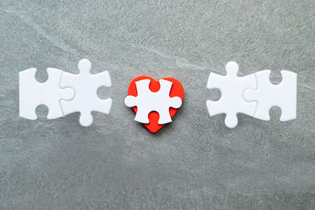 White puzzle pieces and red heart.の写真素材