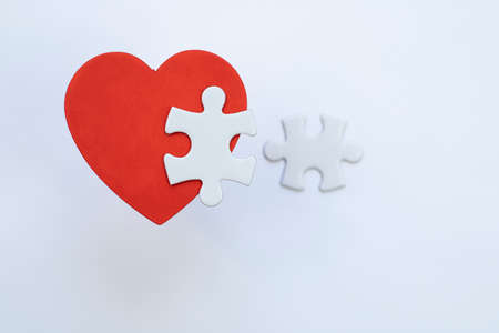 Red heart with white puzzle pieces.の写真素材