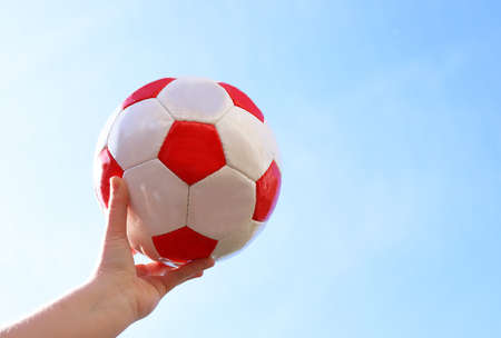 Leather soccer ball in hand of young girl.の写真素材