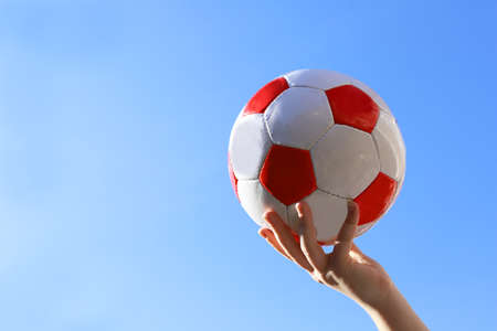 Leather soccer ball in hand of young girl.の写真素材