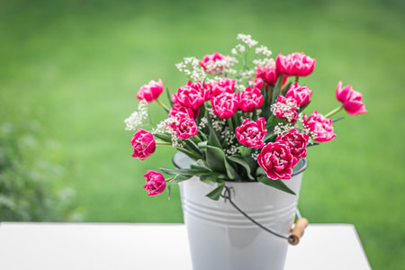 Bouquet of pink tulips in a bucket on the tableの写真素材